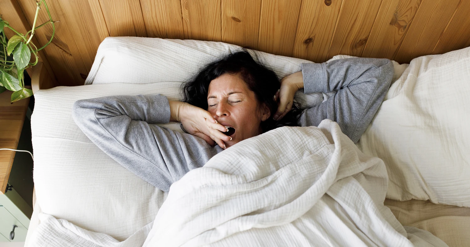 Woman waking up refreshed after quality sleep for healthy skin